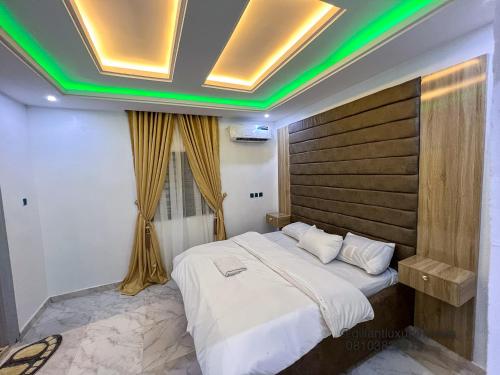 贝宁城Gillant Luxury Homes的一间卧室配有一张带绿色灯光的大床