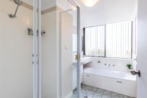 尼尔森湾Magnus Gardens, 10,7 Magnus Street - Beautiful unit close to town with air con and Wi-Fi的白色的浴室设有浴缸和窗户。