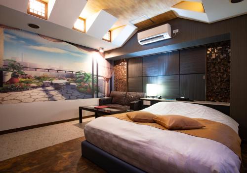广岛Hotel Apricot (Adult Only)的卧室配有一张大床,墙上挂有绘画作品