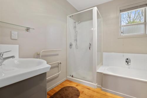 图朗伊Pukeko Lodge - Tūrangi Holiday Home的带淋浴和盥洗盆的白色浴室