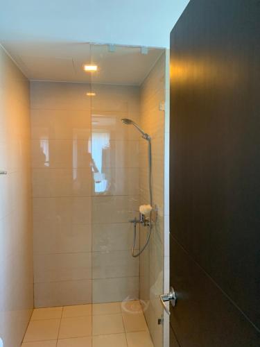 马尼拉Le Maisse Executive Studio 1BR opp Okada的带淋浴的浴室和玻璃门