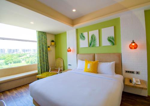 海得拉巴Bloom Hotel - Gachibowli的一间卧室设有一张大床和一个窗户。