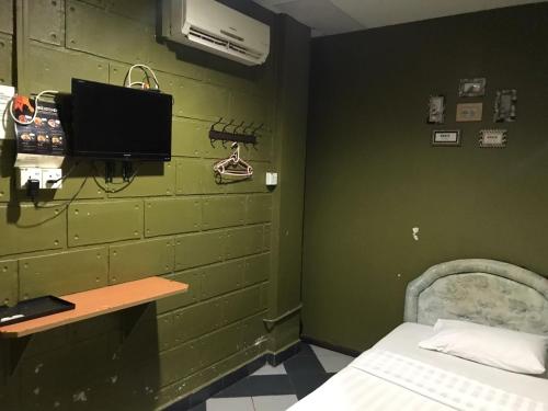 伊纳南MOTEL TERMINAL INN的一间设有绿色墙壁、一张床和一张书桌的客房