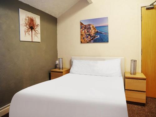布莱克浦OYO The Shores Hotel, Central Blackpool的卧室配有白色的床和2个床头柜