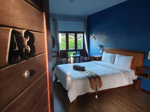 Sungai KolokThebedkolok resort的一间卧室配有一张带蓝色墙壁的大床