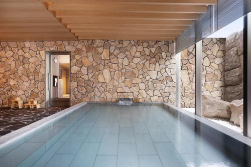 二世古Setsu Niseko的一座石墙房子内的游泳池