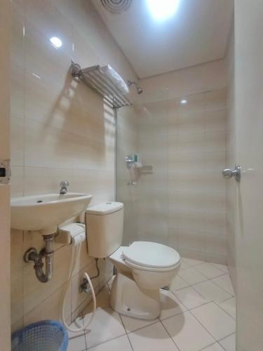 PadangThe Abidin Hotel Syari'ah的浴室配有卫生间、盥洗盆和淋浴。