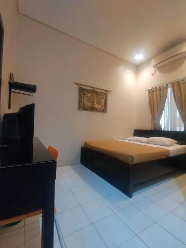 PadangThe Abidin Hotel Syari'ah的一间卧室配有一张床和一台电视