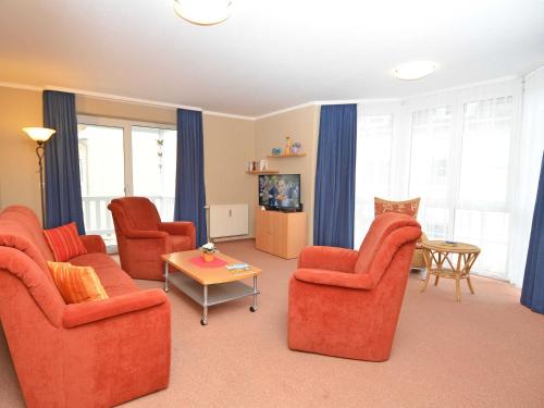 巴贝Ferienwohnungen Schulte的客厅配有橙色椅子和桌子