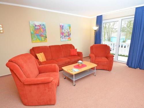 巴贝Ferienwohnungen Schulte的客厅配有2把橙色椅子和桌子