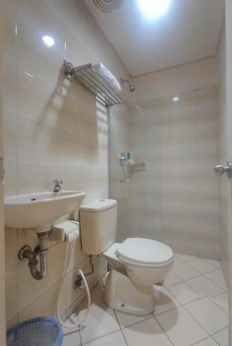 PadangThe Abidin Hotel Syari'ah的浴室配有卫生间、盥洗盆和淋浴。