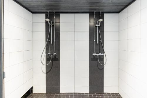 罗瓦涅米Hotel Metsähirvas的浴室设有白色瓷砖墙壁和淋浴。