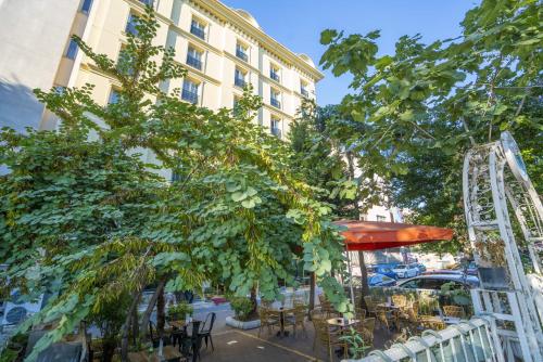 伊斯坦布尔Topkapi Old City Kensington Hotel ISTANBUL的一座配有桌椅的庭院和一座建筑