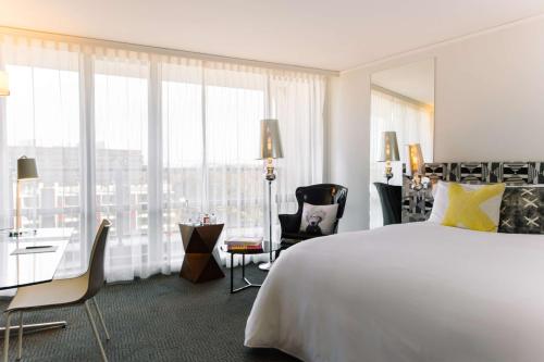堪培拉堪培拉QT酒店的酒店客房设有一张白色大床和一张书桌