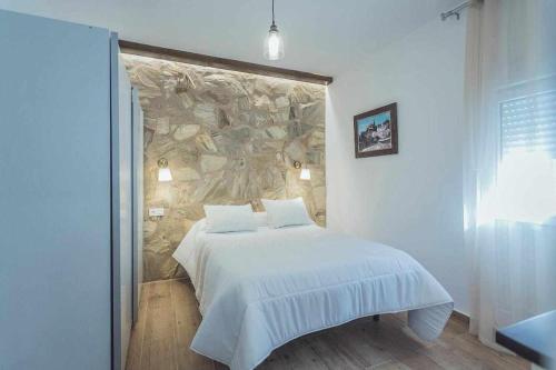乌贝达Alojamiento Suit Royal的一间卧室配有一张石墙床