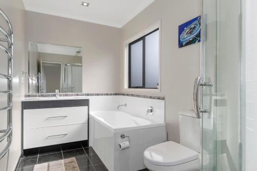 图图卡卡Tutukaka Treat - Wellingtons Bay Holiday Home的白色的浴室设有水槽和卫生间。