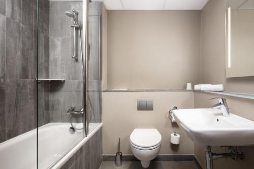 波兹南Ibis Poznan Centrum的浴室配有卫生间、盥洗盆和浴缸。