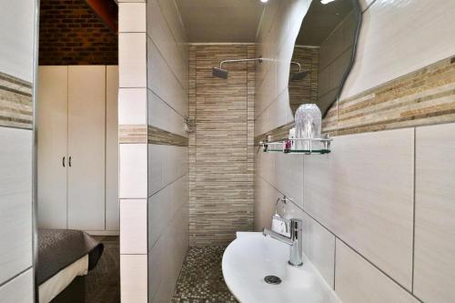 博克斯堡Rudman Townhouses Self-catering Accommodation的一间带水槽和镜子的浴室
