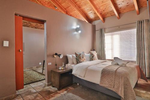 博克斯堡Rudman Townhouses Self-catering Accommodation的一间卧室设有一张大床和一个窗户。