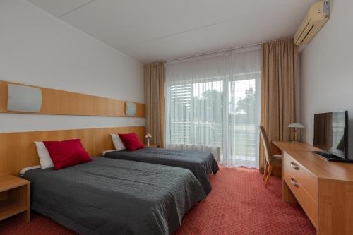 塔尔图Raadimõisa Hotell的酒店客房设有两张床和电视。