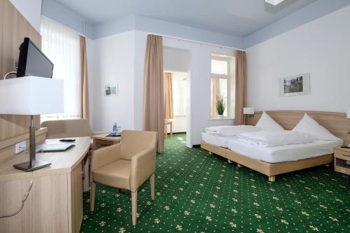 施尔奇Hotel Brockenscheideck的酒店客房,配有一张床、一张桌子和椅子