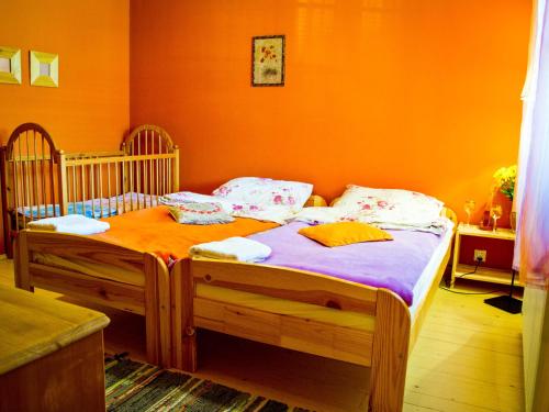 KostrzycaKarkonoskie Siodło的一间卧室设有两张单人床和橙色的墙壁