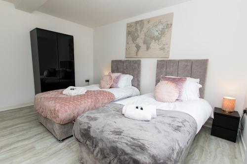 彼得伯勒K Suites - Flat 110 Fulbridge Road的两张位于酒店客房的床,配有白色和粉红色枕头