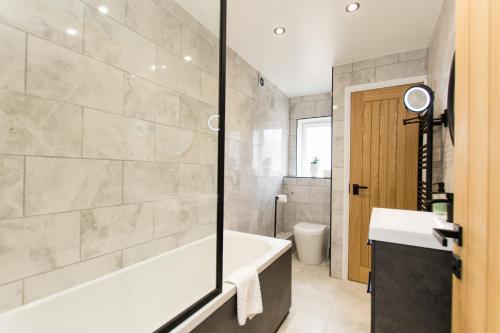 彼得伯勒K Suites - Flat 110 Fulbridge Road的带浴缸、盥洗盆和卫生间的浴室