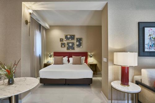 塞维利亚Vincci Molviedro Suites Apartments的酒店客房,设有一张床和两张桌子