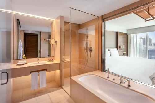 多哈Pullman Doha West Bay的带浴缸、淋浴和盥洗盆的浴室