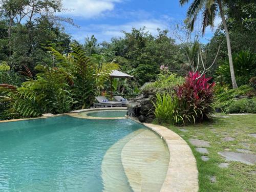 BalianBalian Bliss Retreat Bungalow & Villas的一座种植了树木和植物的庭院内的游泳池