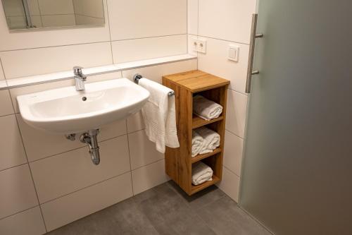 因戈尔施塔特HeindlHof的浴室设有水槽和带毛巾的架子。