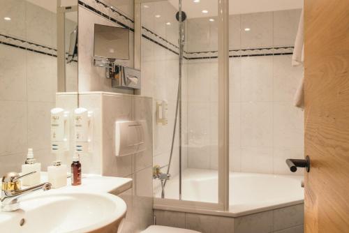 采尔马特la couronne Hotel & Spa的带淋浴、盥洗盆和卫生间的浴室