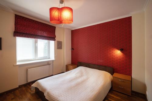 塔林Revalia Airport-Bus Station One-Bedroom Apartment的一间卧室设有一张床和红色的墙壁
