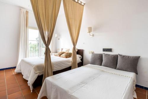 埃尔罗西奥GINVA - Apartahotel El Rocio-Doñana的带窗户的客房内的两张床