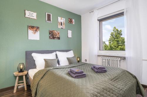 沃尔夫斯堡FREE LIVING - VW näher geht nicht, Parkplatz, Küche, Wlan的一间卧室配有一张带绿色墙壁的床