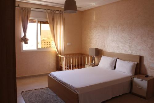 纳祖尔Panorama Apartment Nador Jadid Klima free Parking & Wifi的卧室配有白色的床和窗户。