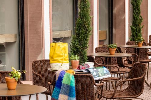 奥贝奈国际之家勤勉酒店的户外庭院配有桌椅和袋子