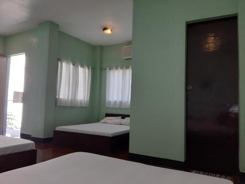 圣胡安Angel and Marie's Basic ACroom for 3-6 pax的客房设有两张床和窗户。