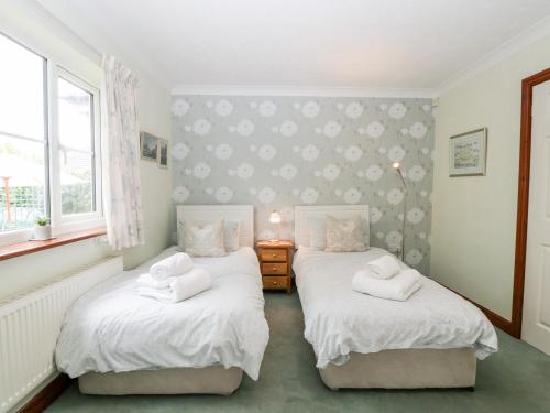 Ewyas HaroldHurst Green的带2扇窗户的客房内的2张单人床