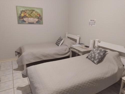 基特曼斯胡普Larochelle Guesthouse的客房设有两张床和一张墙上照片的书桌。