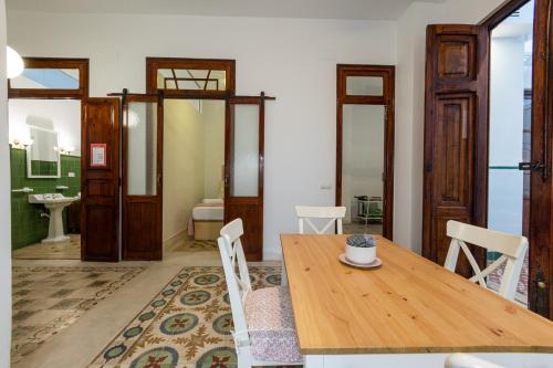 瓦伦西亚FLORIT FLATS - Traditional House in El Cabanyal的一间带木桌的用餐室和一间浴室