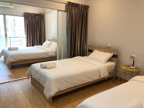 曼谷Tang Guang Aeum Coffee Residence的酒店客房设有两张床和窗户。