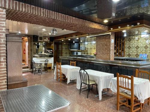 圣科洛马·德法尔琼方达酒店的一间带桌椅的餐厅和一间酒吧