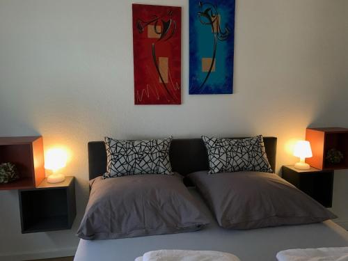 克莱沃Haus Am Damm的一张带两盏灯的床和墙上的两幅画