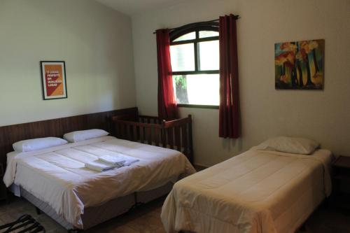 里贝朗普雷托Itaygua Hotel的一间卧室设有两张床和窗户。