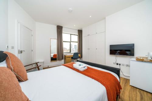 WoolwichEquitable Hotel的配有一张床和一台平面电视的酒店客房