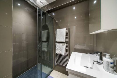 WoolwichEquitable Hotel的带淋浴、水槽和玻璃淋浴间的浴室