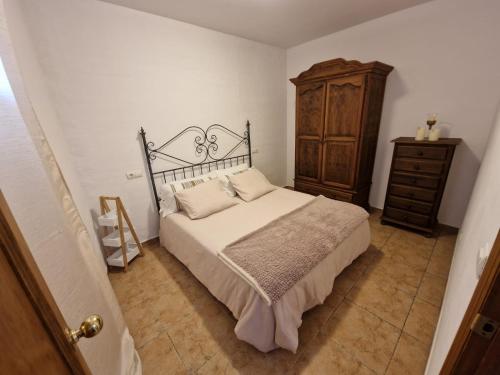 马贝拉Apartamento Marbella的一间卧室配有一张床和一个木制梳妆台