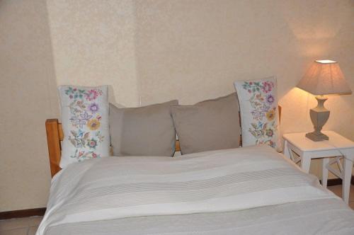 安锡Appartement dans la vieille ville, en face du château的卧室配有带枕头和灯的白色床